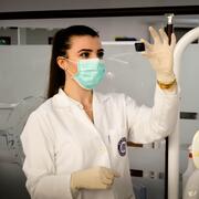 researcher holding up a microscope slide